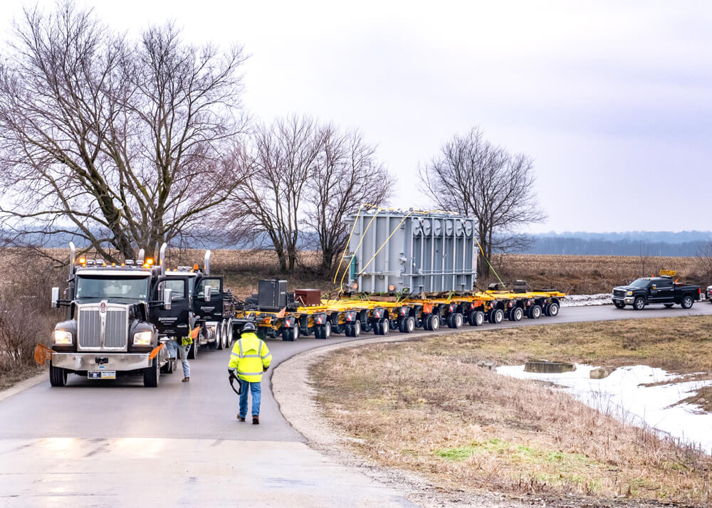 Buckingham personnel with semi and Goldhofer trailer with transformer