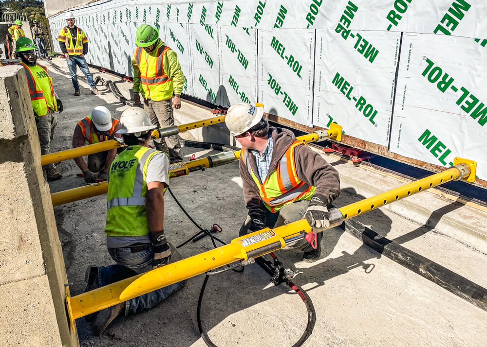 Workers use Buckingham jacking-shoring posts to position an accelerated bridge construction section