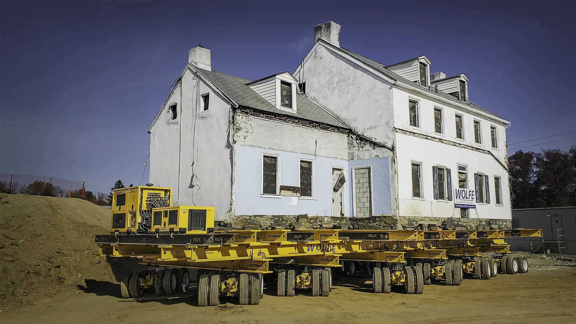 White stone house on yellow dollies and steel beams